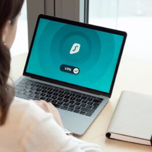 A woman working on a laptop with a VPN icon on screen for secure online browsing.