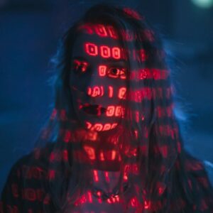 A woman with red binary code projected on her face, signifying technology and cybersecurity.